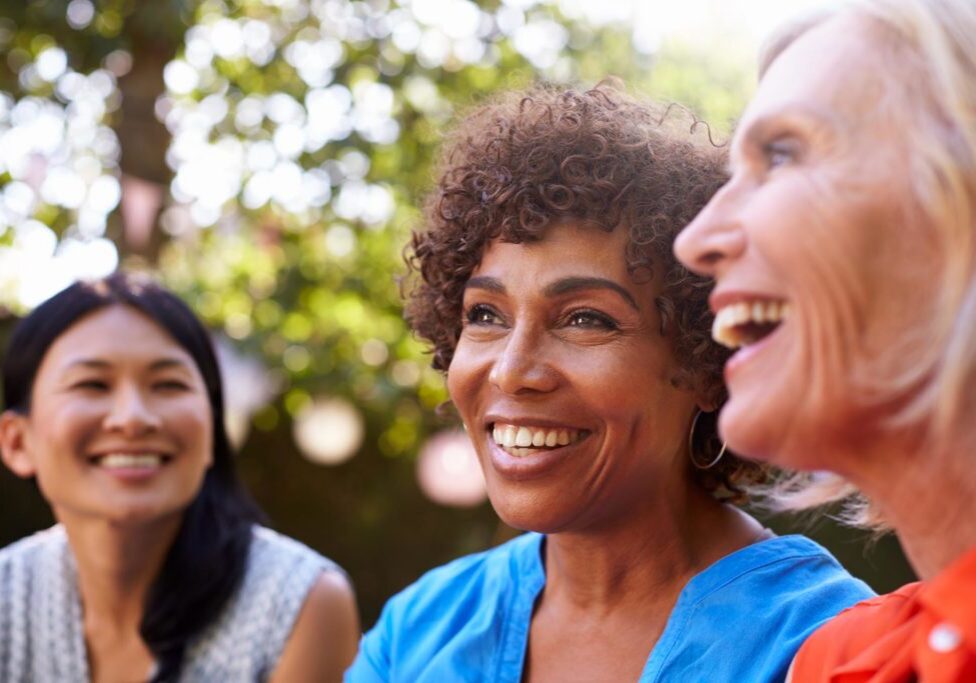 Mature Female Friends Socializing In Backyard Together
